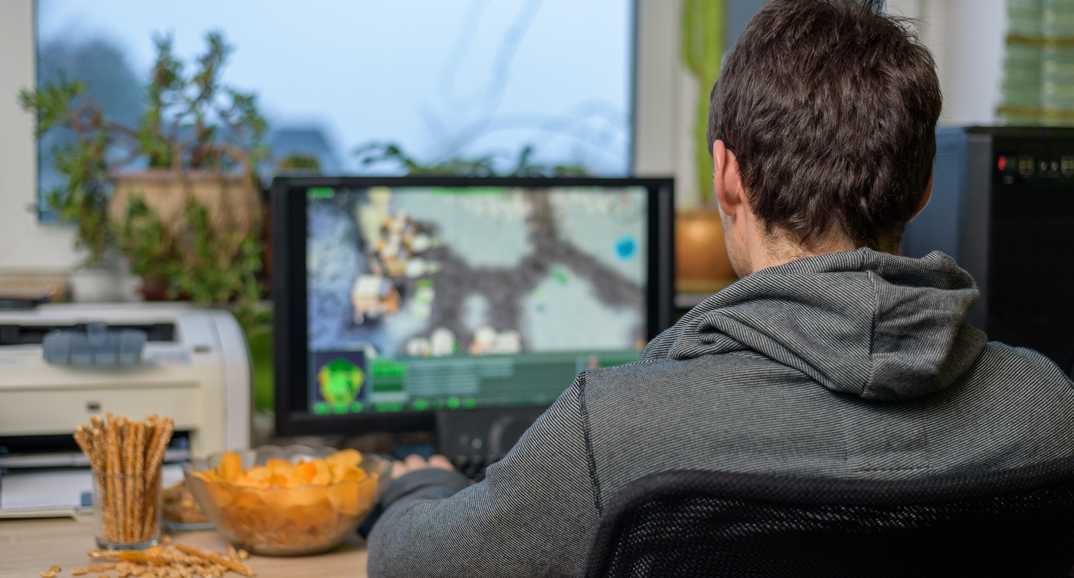 male gamer playing strategy game on computer with snacks lying on table - stock photomale gamer playing strategy game on computer with snacks lying on table - stock photomale gamer playing strategy game on computer with snacks lying on table - stock photo