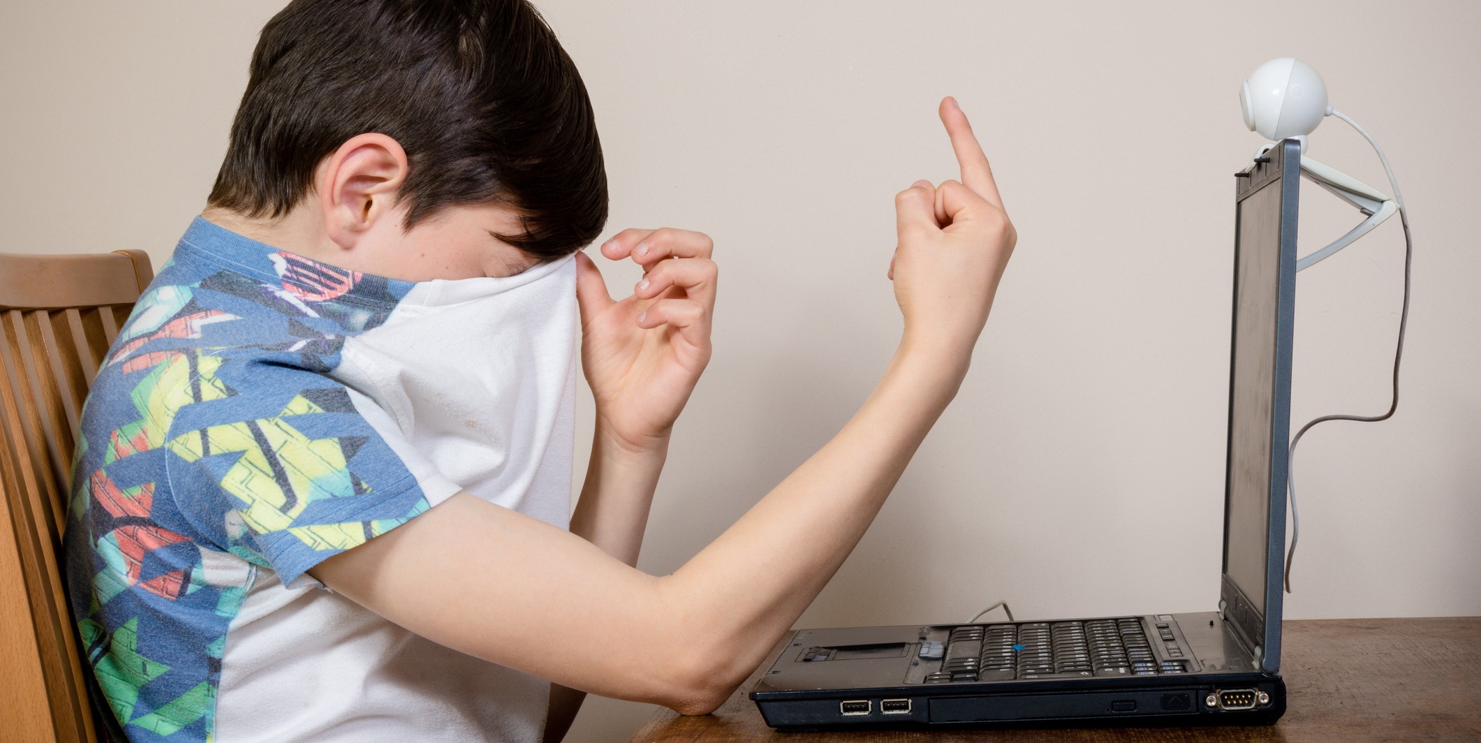 Young boy giving the finger to a webcam after getting a request to send a picture